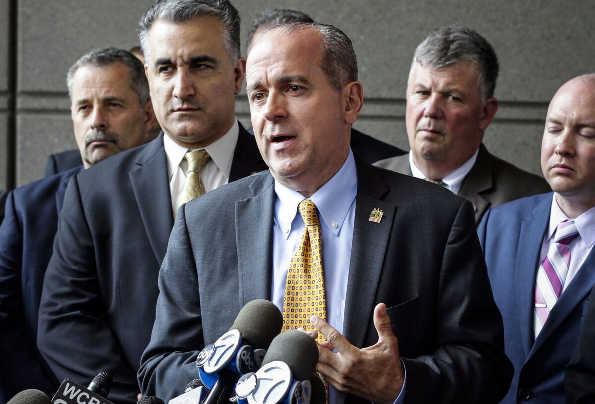 FILE — New York Police Department Sgt. Ed Mullins, center, head of the Sergeants Benevolent Association, speaks during a news conference in the Bronx borough of New York, May 31, 2017. Mullins, the former head of New York City's police sergeants' union, has been punished with a loss of 70 vacation days, almost $32,000 in lost pay, after being found guilty in NYPD disciplinary proceedings of improperly disclosing information and using inappropriate language in social media postings, the NYPD said Friday, Nov. 5, 2021. (AP Photo/Frank Franklin II, File)