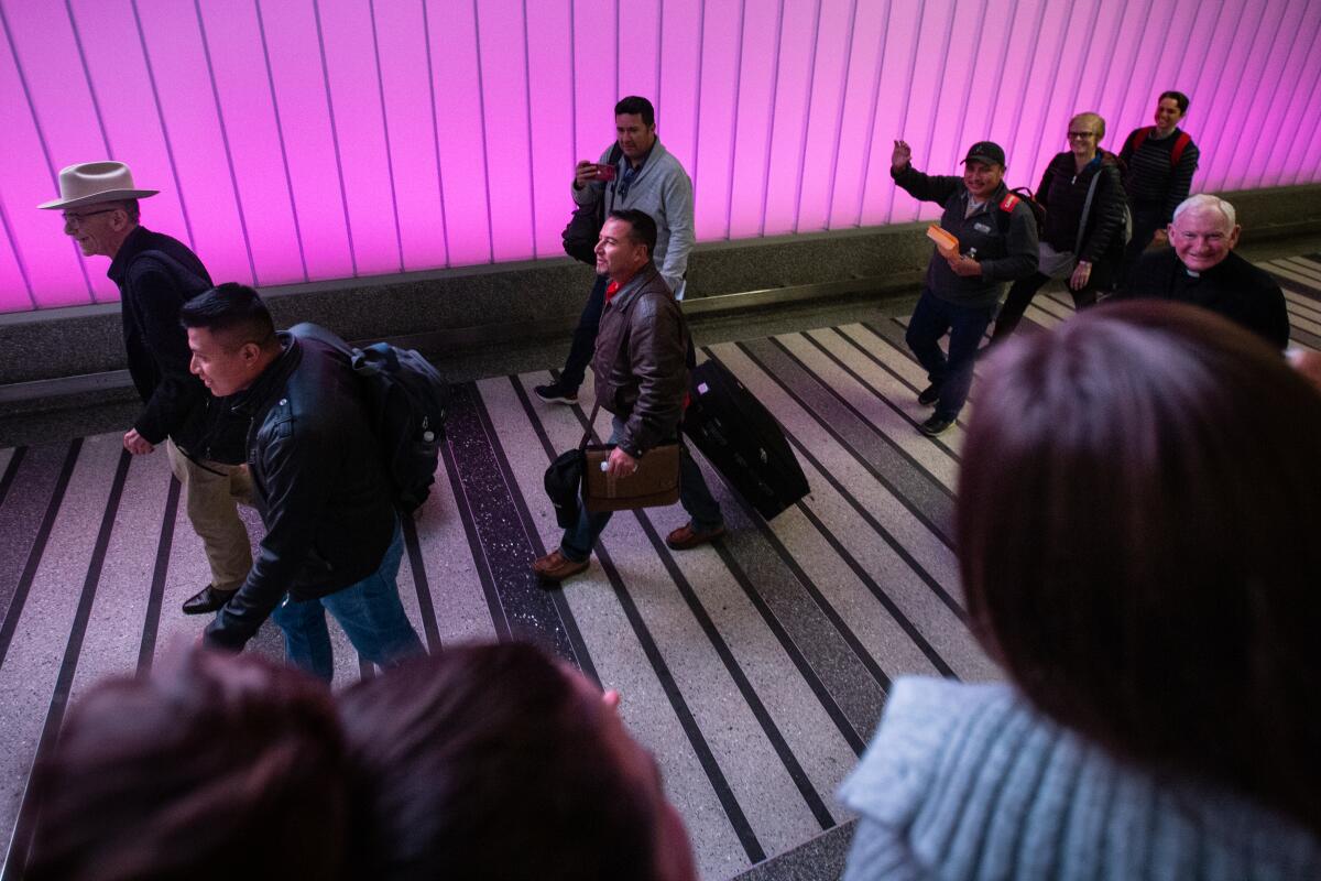 Fernando Arredondo, center, walks into the arrival area at the Tom Bradley terminal