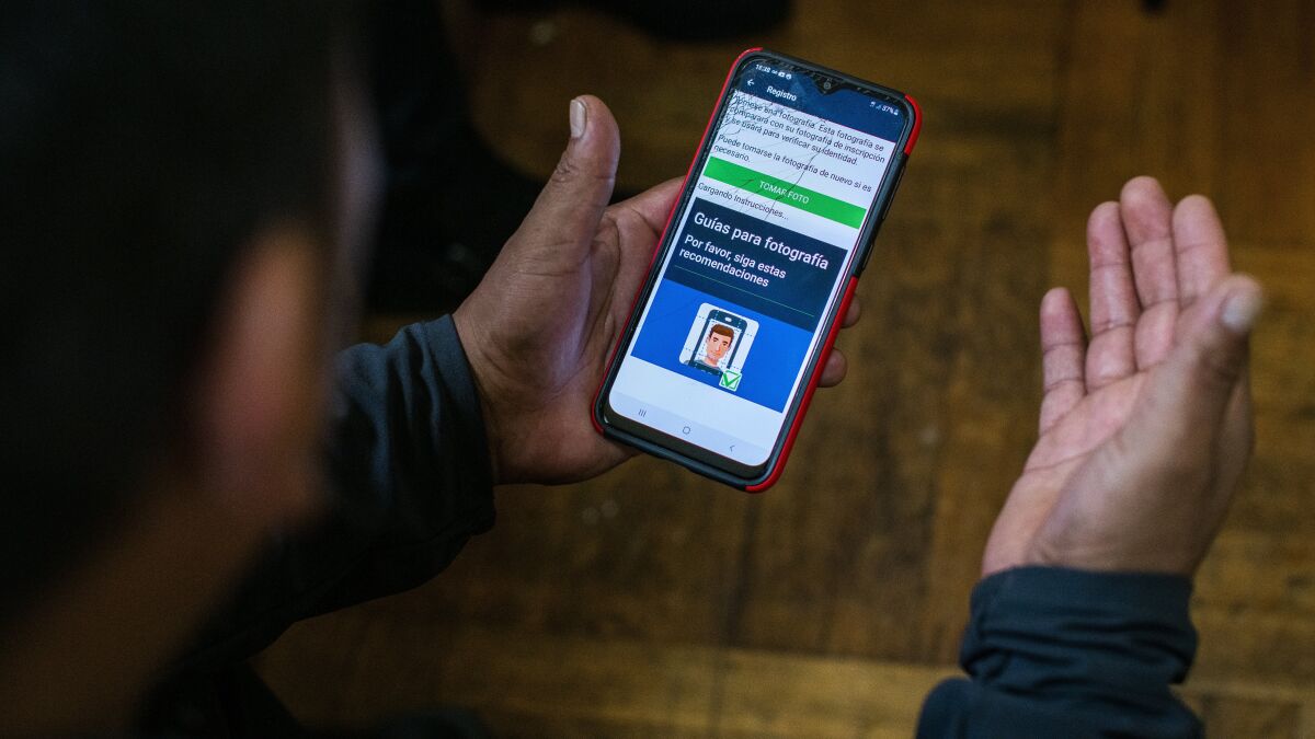  Ecuadorian immigrant Neptali Chiluisa shows the app that he uses for reporting his location