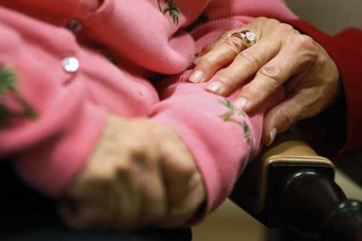 The executive director of The Methodist Home of the District of Columbia Forest Side, an Alzheimer's assisted-living facility, puts her hand on the arm of resident.