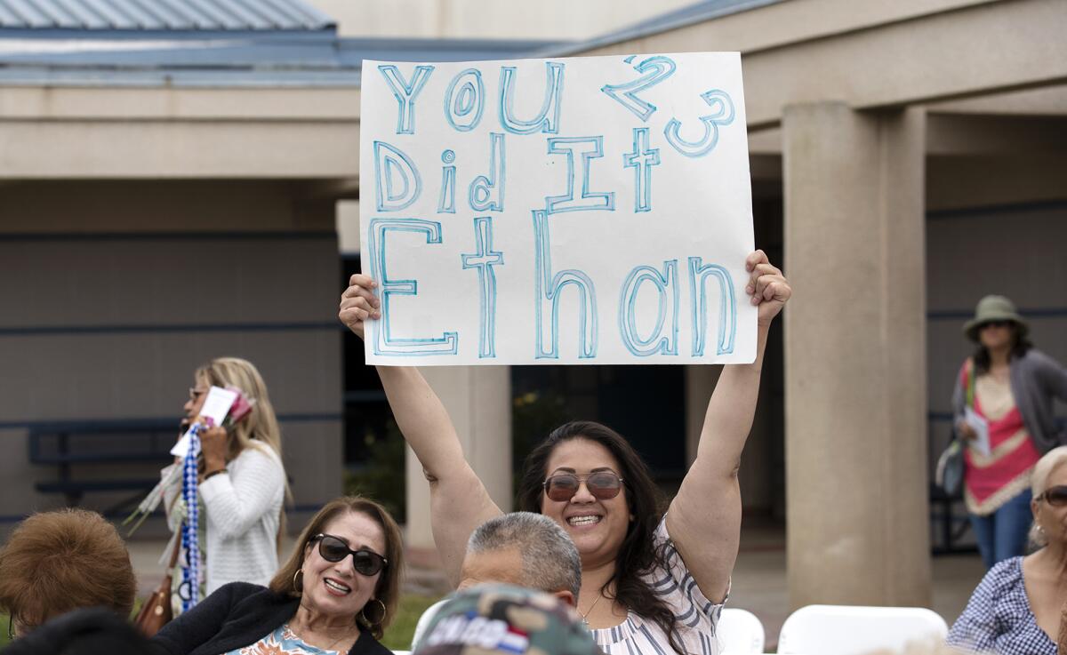 Rachel Miranda holds a sign for Ethan Melendez during the commencement ceremony for Valley Vista High School on Thursday.