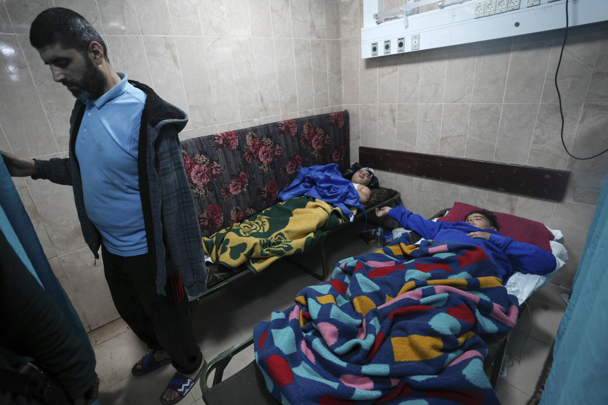 People wounded in Israeli bombardment of Gaza await treatment at a hospital