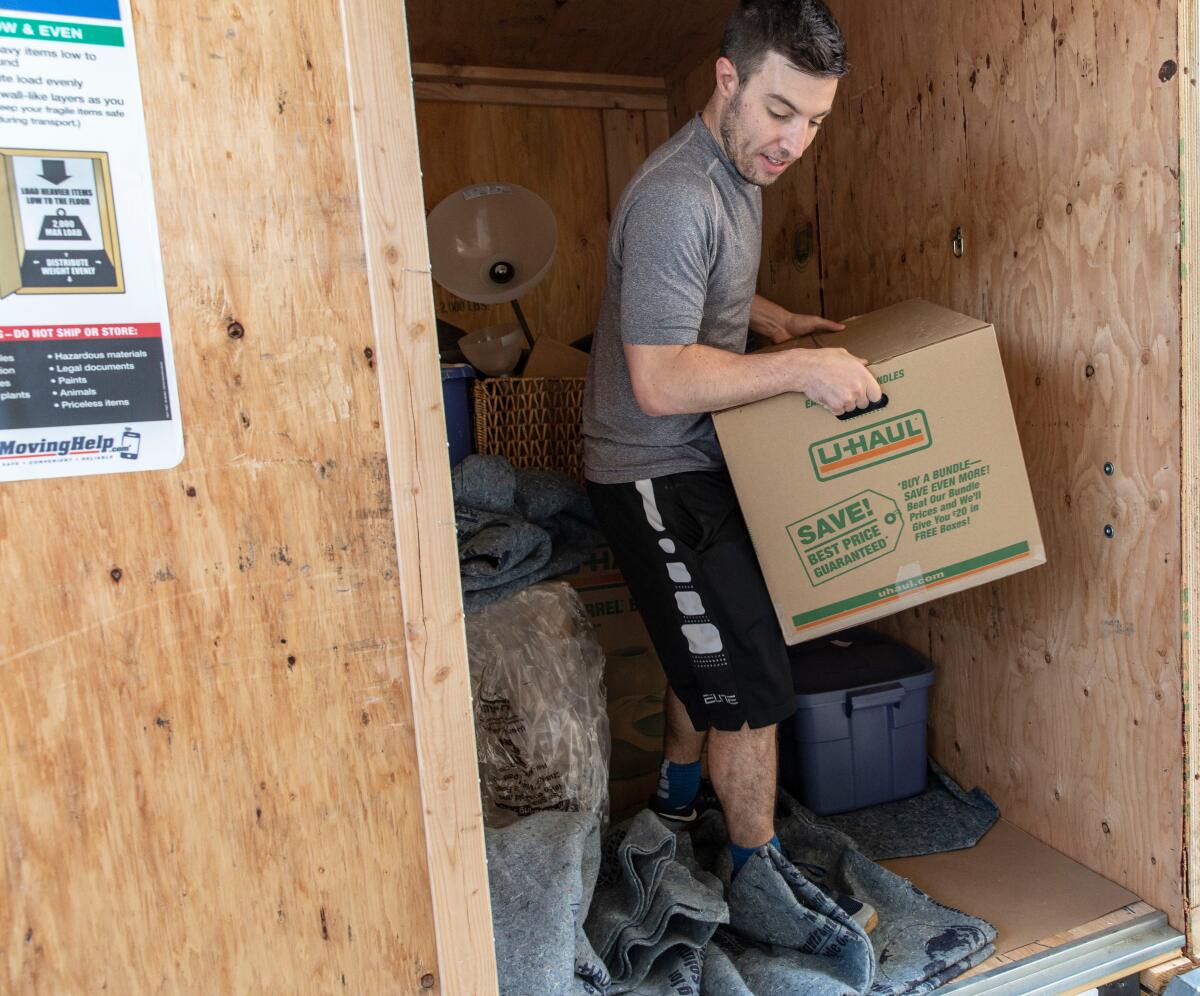 Los Angeles Times reporter Liam Dillon moves boxes into his apartment in Palms in October.
