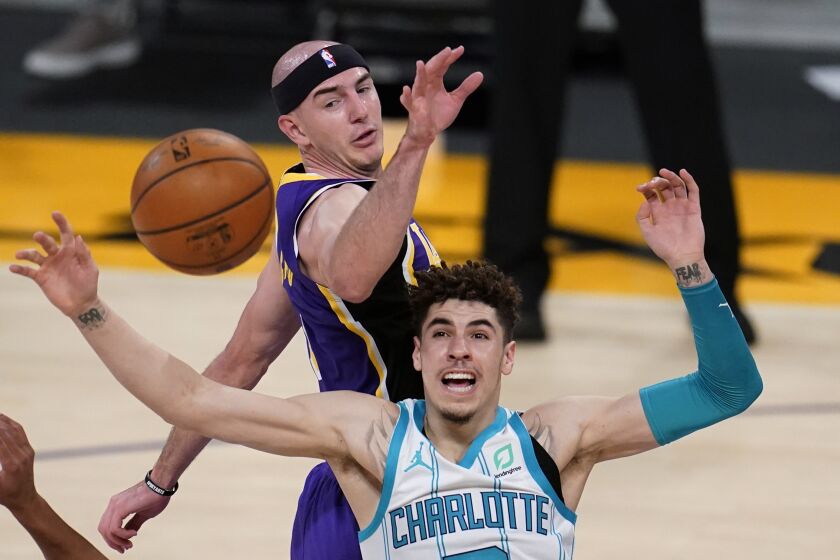 Charlotte Hornets guard LaMelo Ball, bottom, works for a rebound next to Los Angeles Lakers guard Alex Caruso during the second half of an NBA basketball game Thursday, March 18, 2021, in Los Angeles. (AP Photo/Marcio Jose Sanchez)