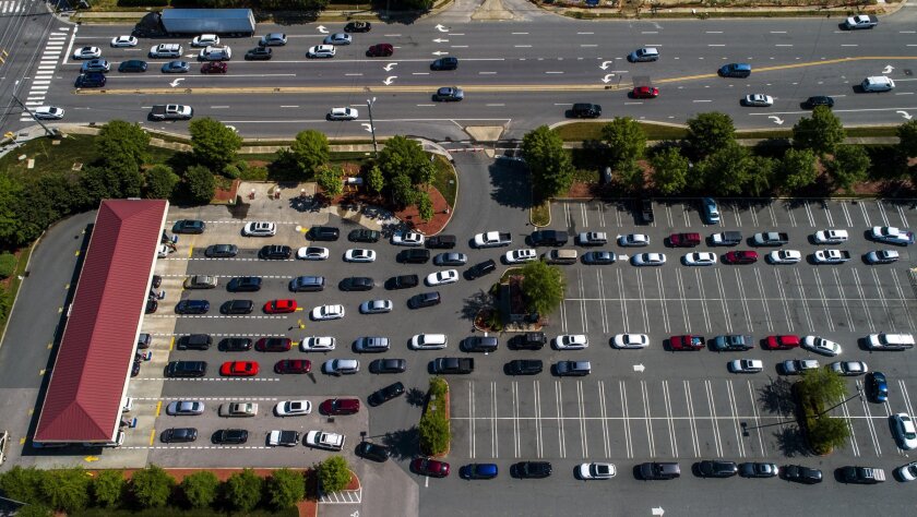 Vehicles wait in lines at the Costco in Raleigh, N.C., Thursday, May 13, 2021. Operators of the Colonial Pipeline say they began the process of moving fuel through the pipeline again on Wednesday, six days after it was shut down because of a cyberattack. (Travis Long/The News & Observer via AP)