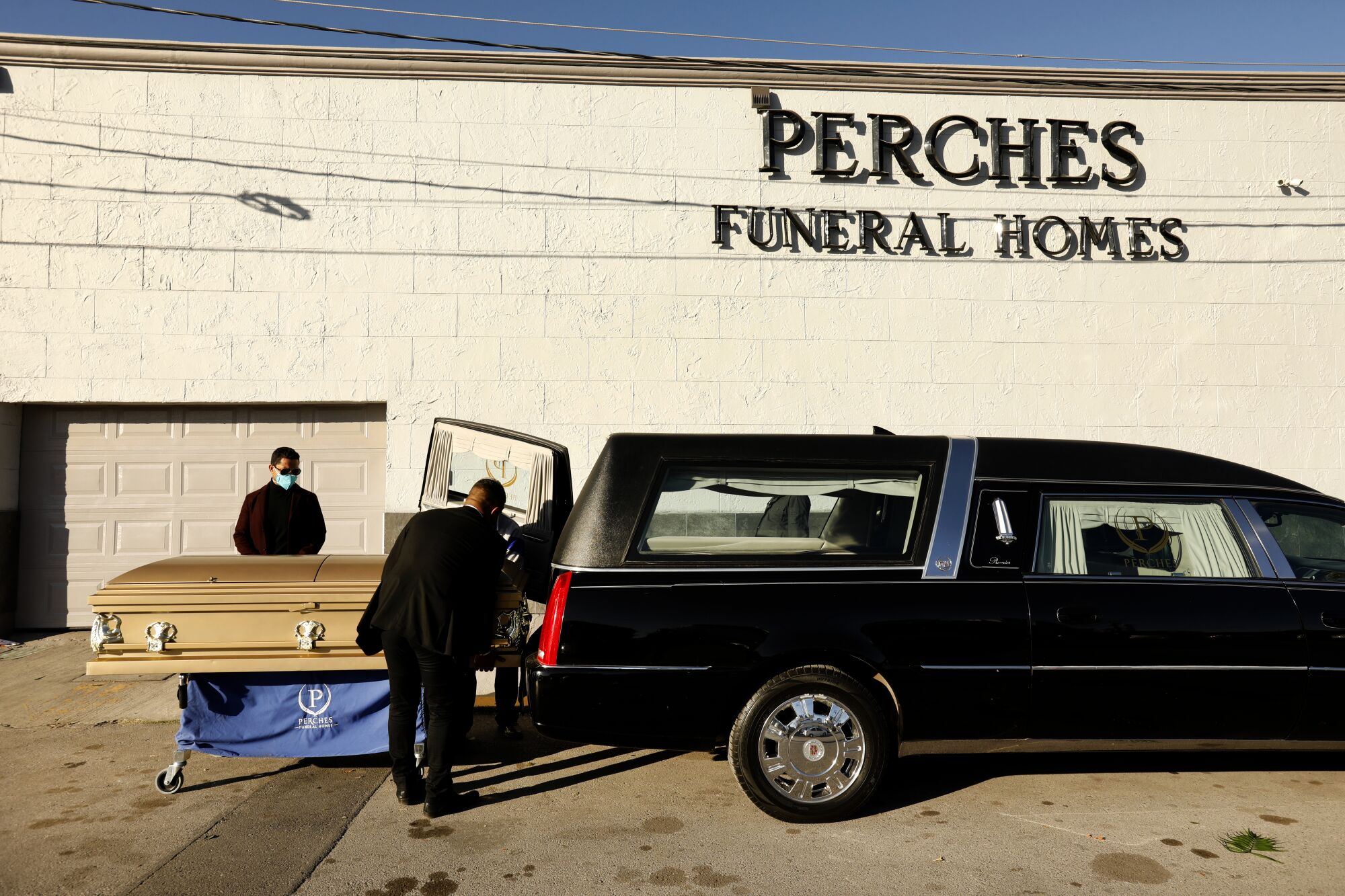 Dr. David González Velazco, left, beside his brother-in-law's casket outside Perches Funeral Home in Juarez, Mexico. 