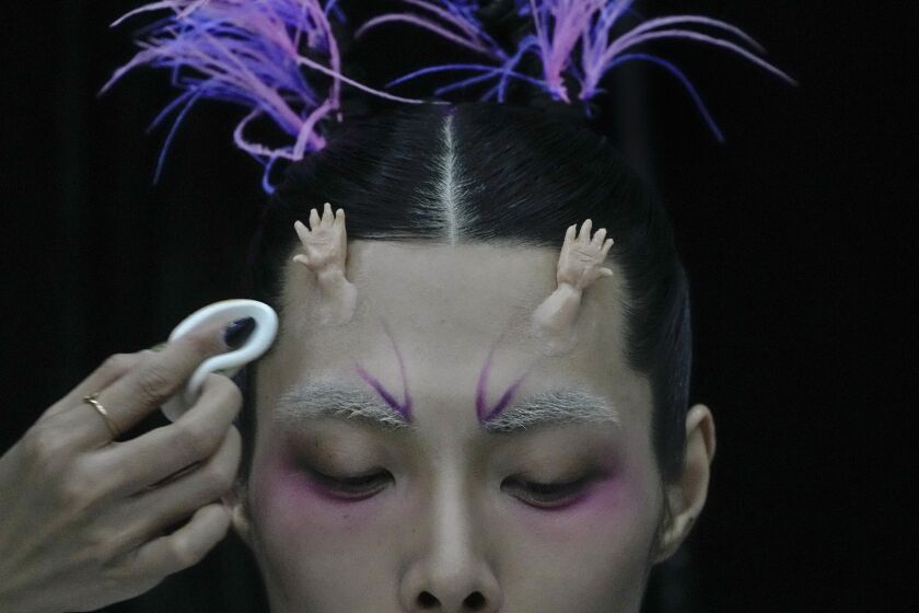 A model for the Dieyingchongchong collections by Chinese designer Dong Yaer has final makeup applied backstage during the China Fashion Week in Beijing, Tuesday, March 28, 2023. (AP Photo/Andy Wong)