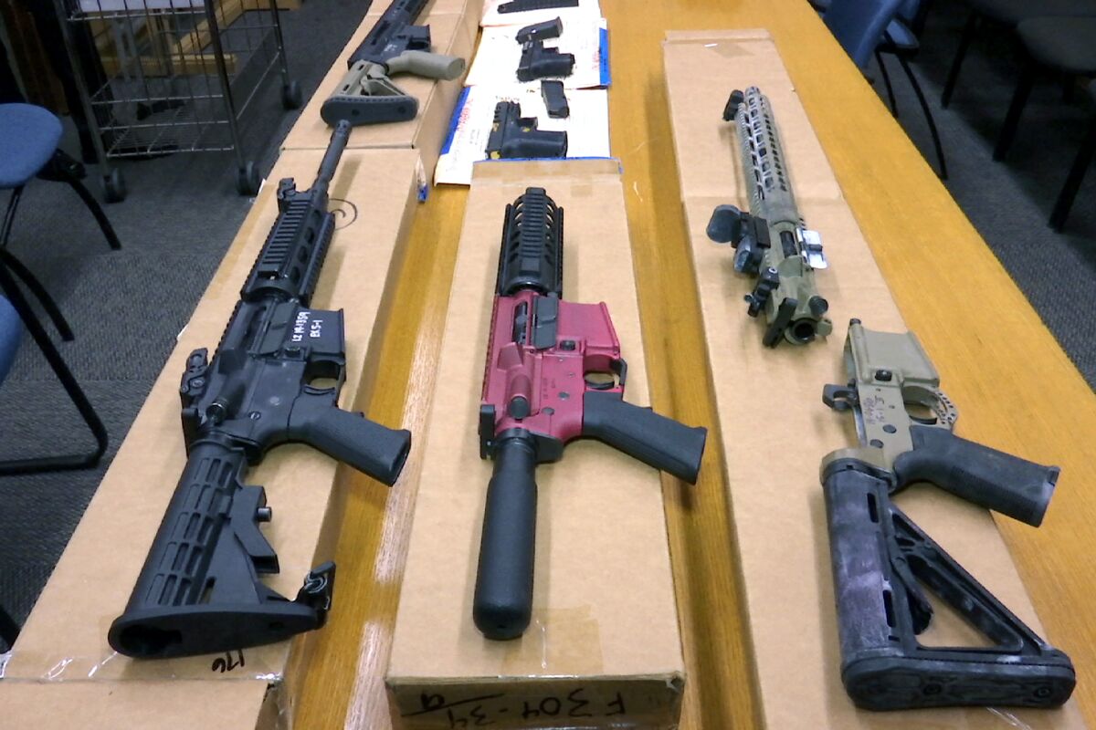 Firearms are exhibited on a table.