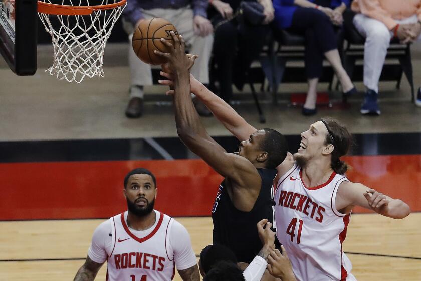 The Clippers' Serge Ibaka, middle, drives to the basket past the Rockets' Kelly Olynyk (41) on May 14, 2021, in Houston.