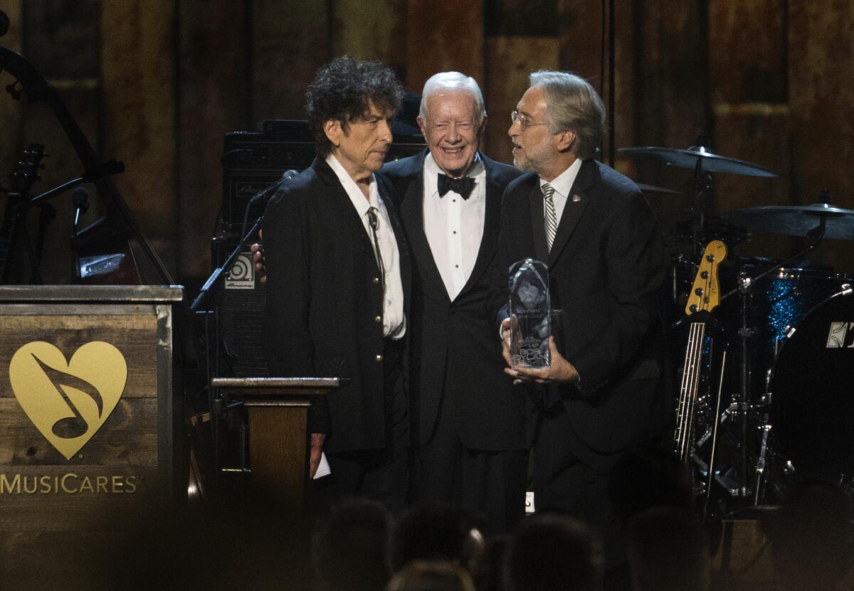 Former President Jimmy Carter introduces Bob Dylan as the 2015 MusiCares Person of the Year with Neil Portnow, president of the National Academy of Recording Arts and Sciences, during the MusiCares concert at the Convention Center.