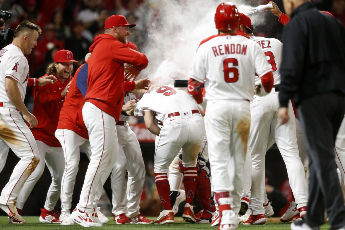 Angels rookie Zach Neto (9) is surrounded by teammates after he scored on a wild pitch for the winning run May 5, 2023. 