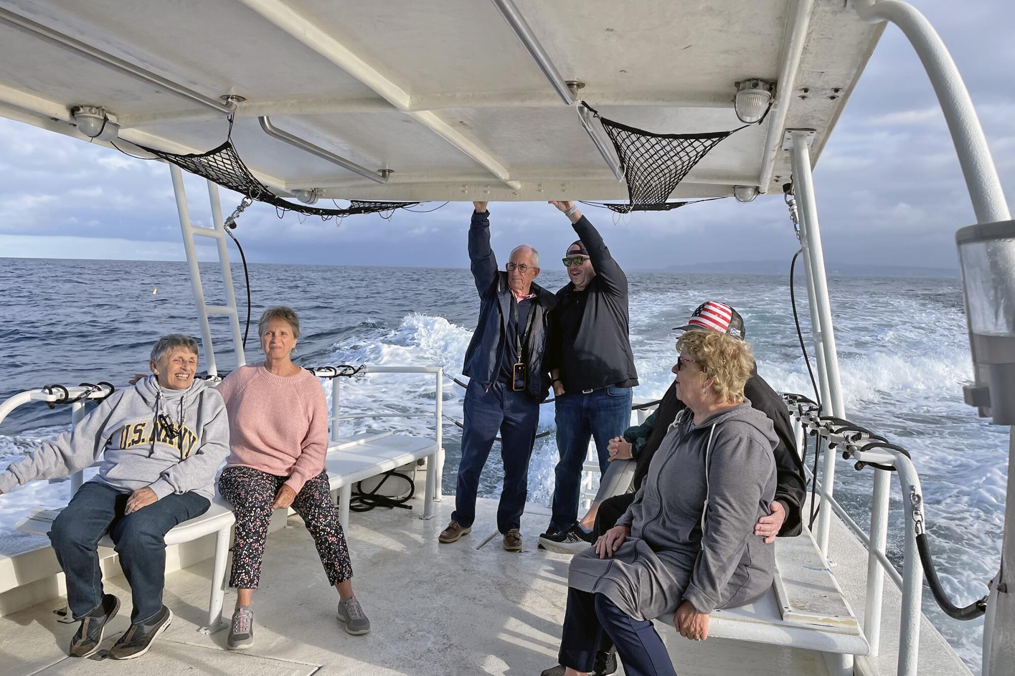 Relatives and friends of Gus Herrmann ride out in a boat to pay their respects