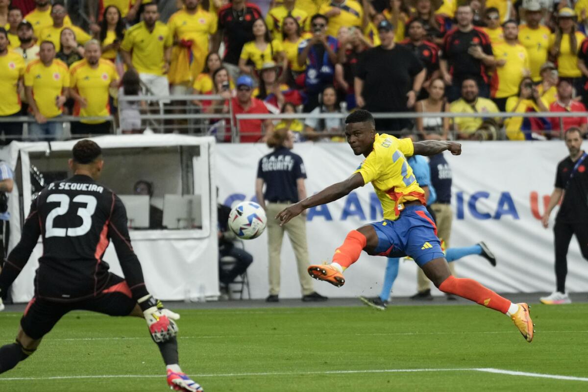 El atacante Jhon Córdoba (derecha) anota el tercer gol de Colombia