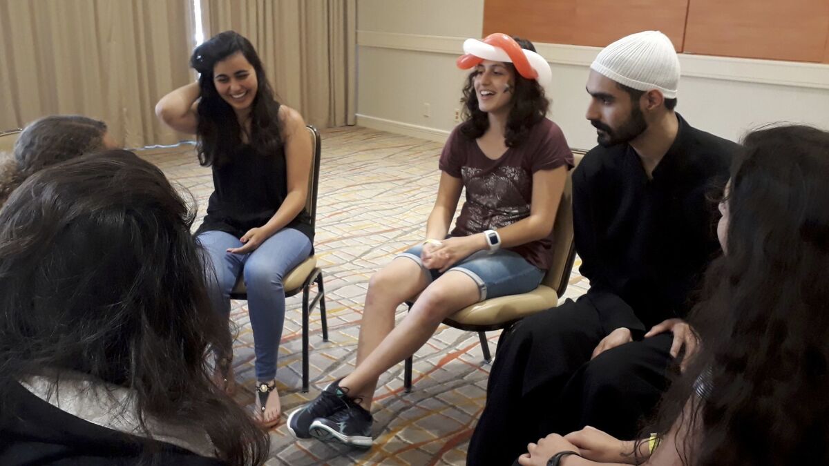 Daniel Halabi, 22, a sheikh or religious leader in the Druze faith, leads a discussion with Carmen Masri, left, and Luna Masri at the American Druze Society conference in Irvine in July.