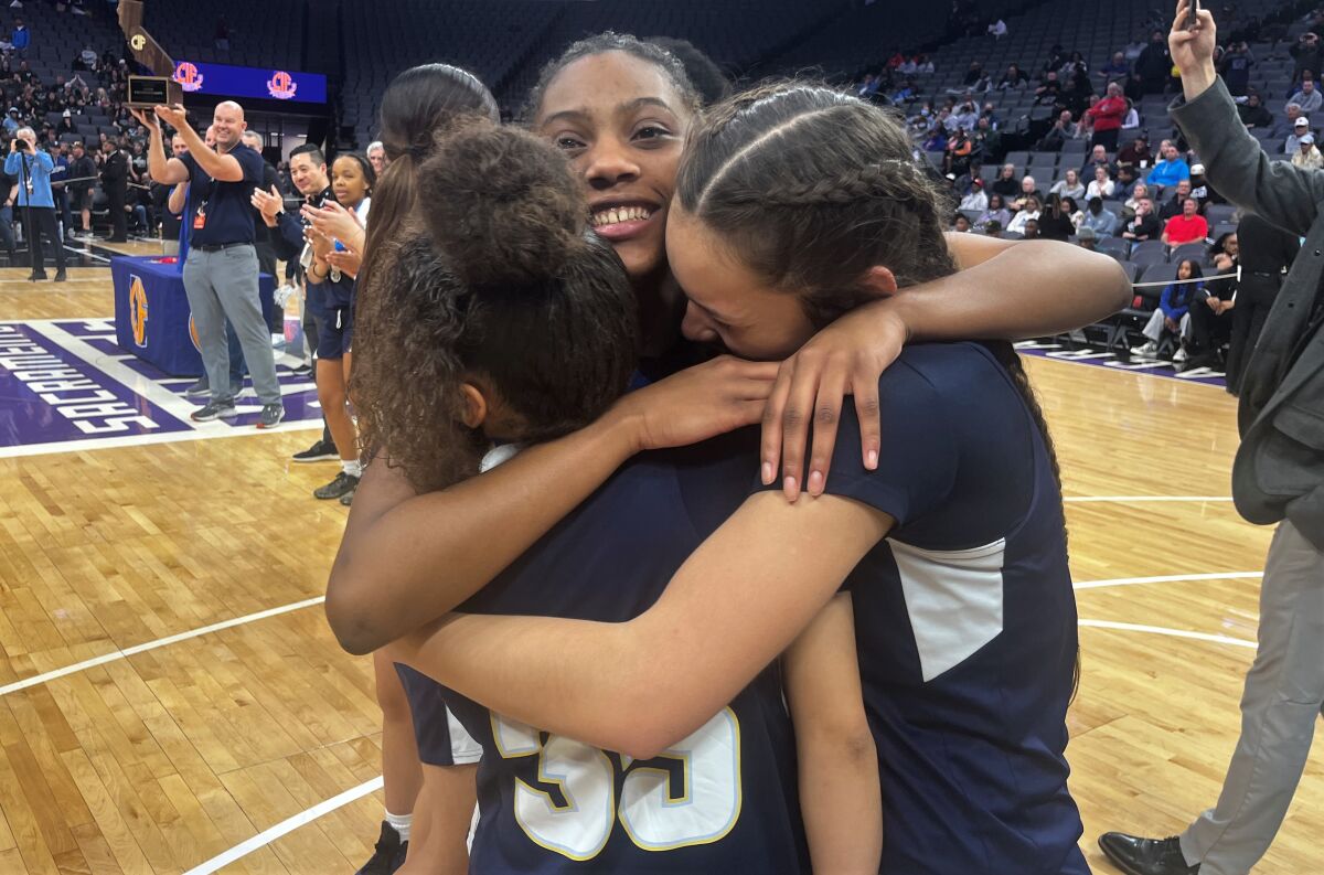 Los Osos star Jackie Polk (35) is embraced by teammates after leading the team to the Division III state title in Sacramento.