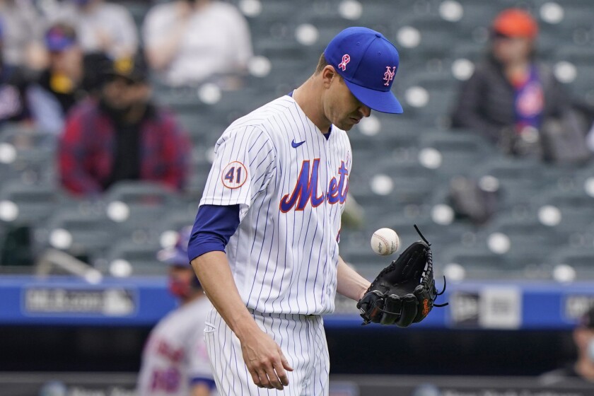 New York Mets starting pitcher Jacob deGrom tosses the ball during the fifth inning of a baseball game against the Arizona Diamondbacks, Sunday, May 9, 2021, in New York. deGrom left the game in the sixth inning after throwing only two warmup pitches. (AP Photo/Kathy Willens)
