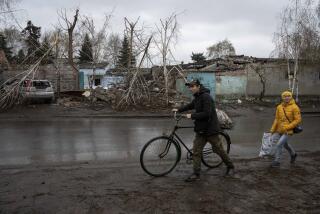 Locals walk past a house which was destroyed by Russian attack in Kostiantynivka, Ukraine, Thursday, April 6, 2023. (AP Photo/Evgeniy Maloletka)