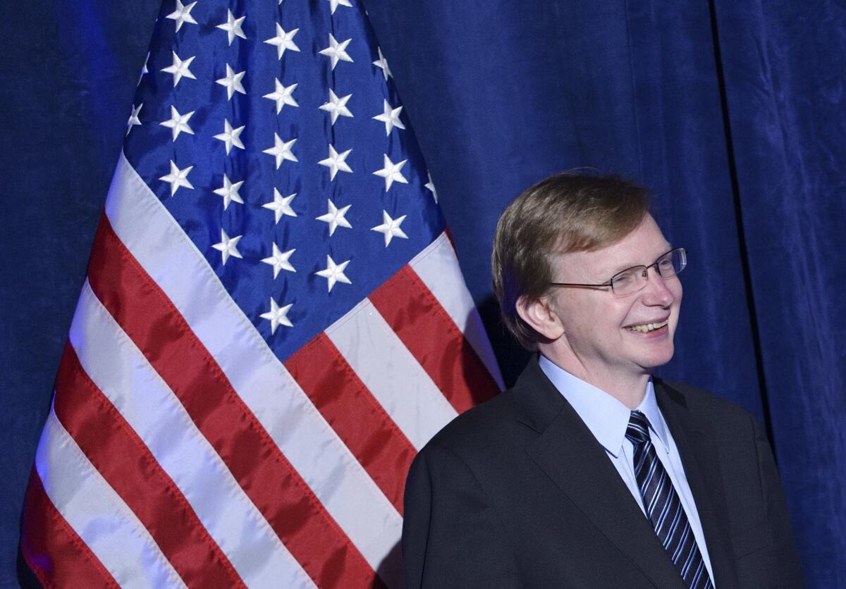 Organizing for Action head Jim Messina reacts to President Obama's remarks at the group's dinner at the St. Regis Hotel in Washington.