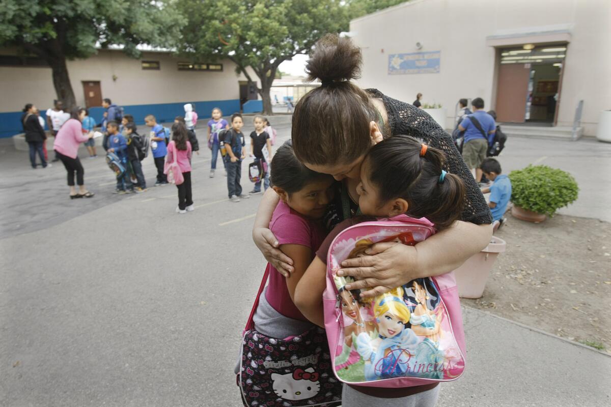 Principal Irma Cobian, shown hugging two students at Weigand Avenue Elementary, had to leave the school after a group of parents petitioned for her removal. The school's faculty eventually left the school in protest.