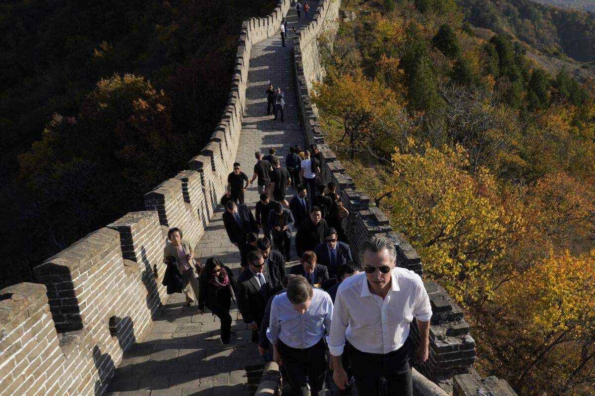 Gov. Gavin Newsom walks up a section of the Great Wall in China