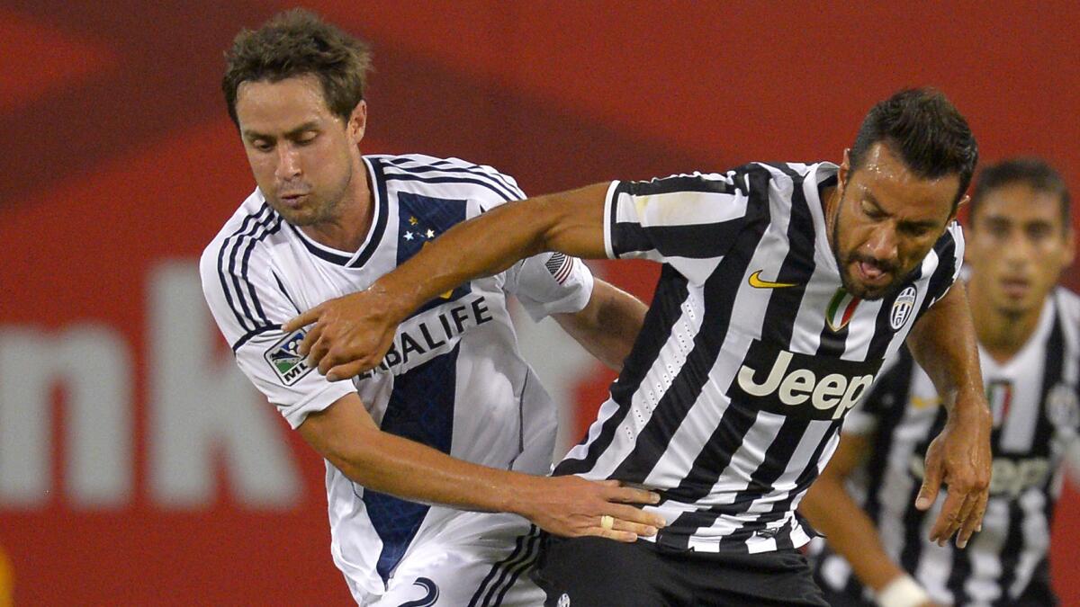 Galaxy defender Todd Dunivant, left, battles Juventus forward Fabio Quagliarella for the ball during an International Champions Cup match on Aug. 3, 2013. Dunivant says MLS players are willing to sit out games if a new collective bargaining agreement is not in place.