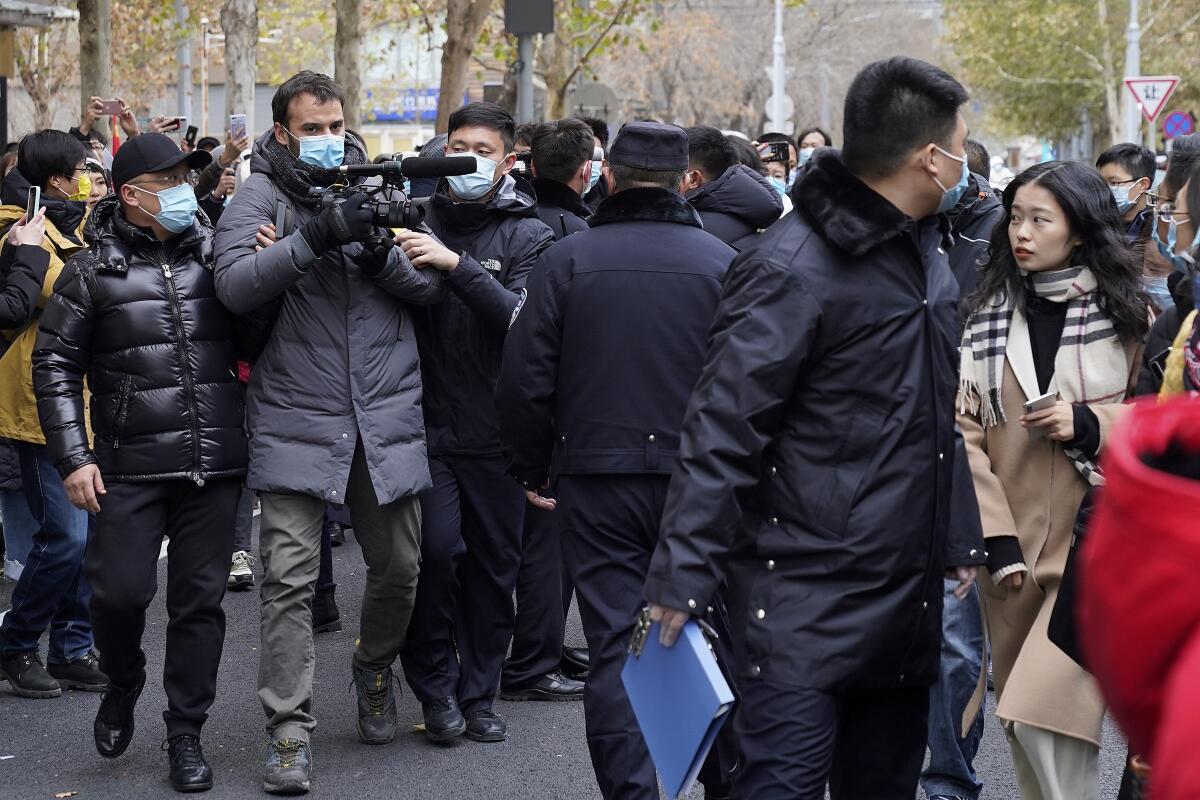 Zhou Xiaoxuan, right, looks as Chinese police block a foreign journalist as she arrives at a courthouse in Beijing.