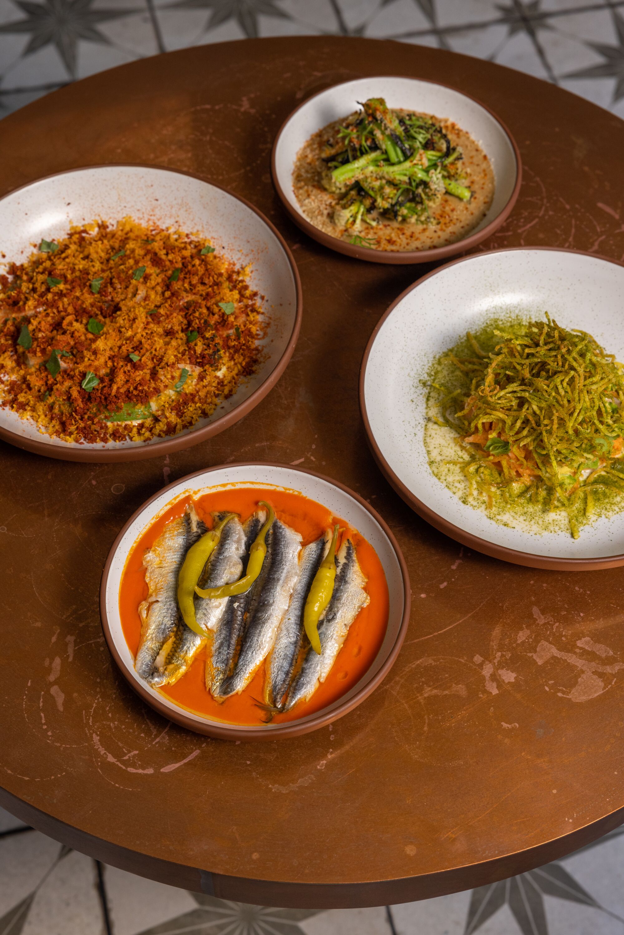 A table with four vegetable dishes from Bar Chelou in Pasadena.