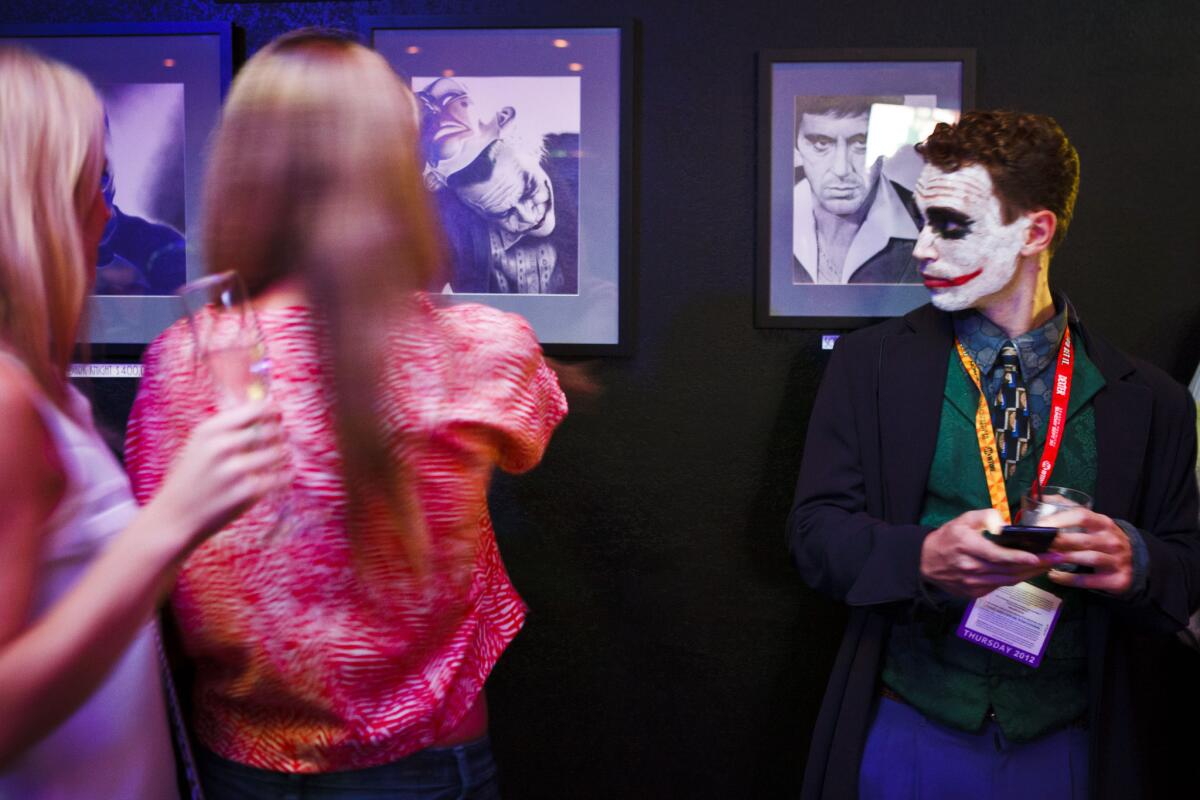 Dressed as the Joker, Coy Jandreau makes some friends at the Merk restaurant during Comic–Con on July 12, 2012.