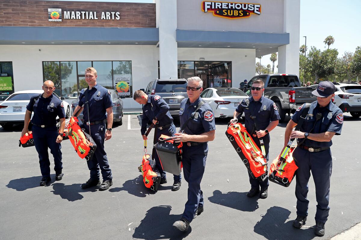 Members of the Huntington Beach Fire Department pick up six new Scott rapid intervention team packs on Wednesday. 