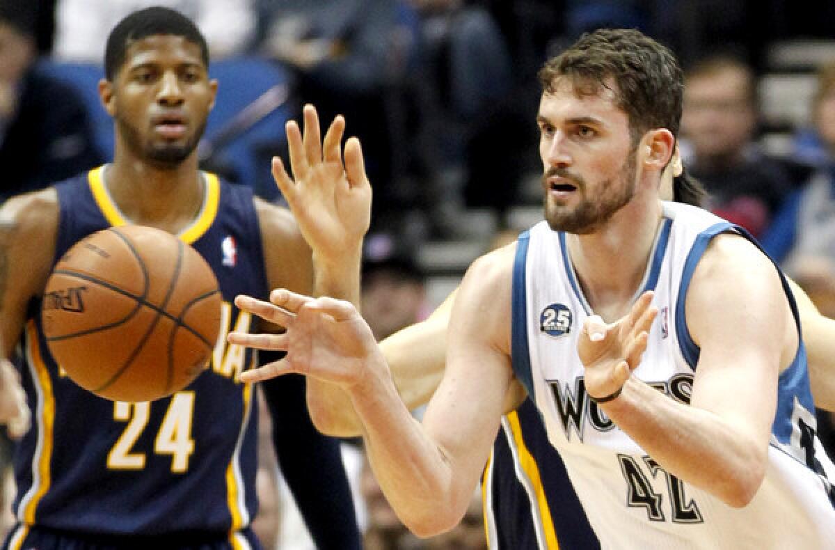 Timberwolves power forward Kevin Love passes while Pacers forward Paul George watches the play during their game in Minneapolis on Feb. 19.