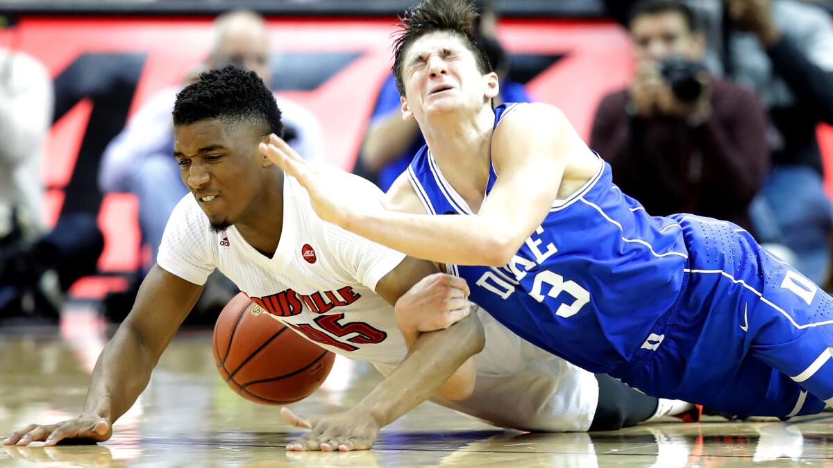 Louisville's Donvan Mitchell (45) and Duke's Grayson Allen (3) dive after a loose ball during their game Saturday.