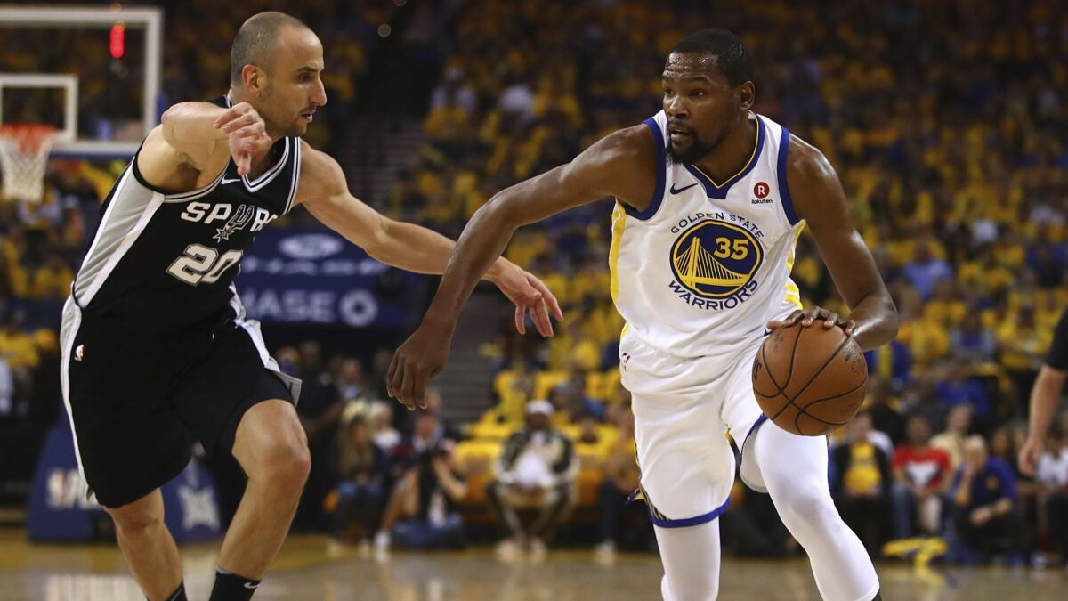 Golden State Warriors' Kevin Durant, right, drives the ball against San Antonio Spurs' Manu Ginobili (20) during the first half.