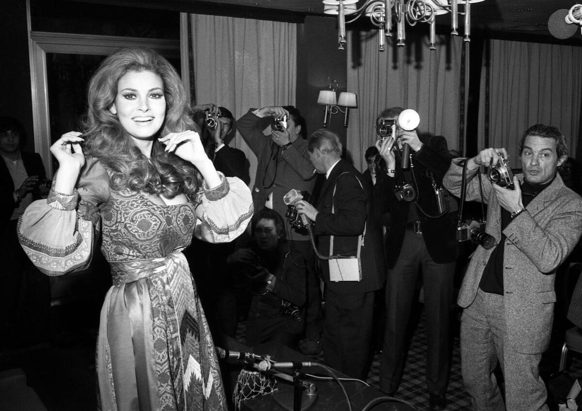 Raquel Welch poses with journalists in Paris in 1970. 