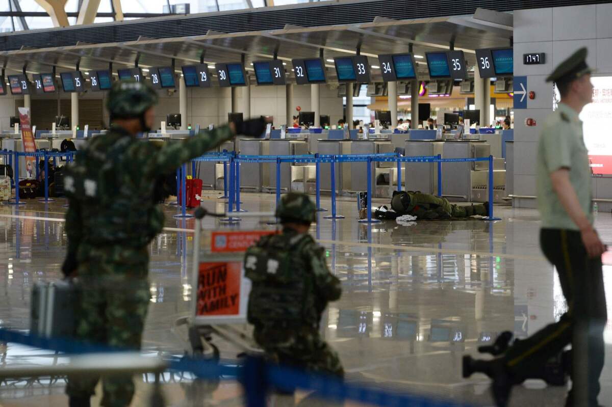 A paramilitary bomb disposal expert (background, right) inspects luggage left near a check-in counter after an explosion at Pudong Airport in Shanghai on Sunday.