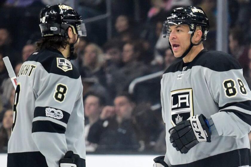 Kings center Jarome Iginla talks with defenseman Drew Doughty before a first-period faceoff against the Canucks on March 4.