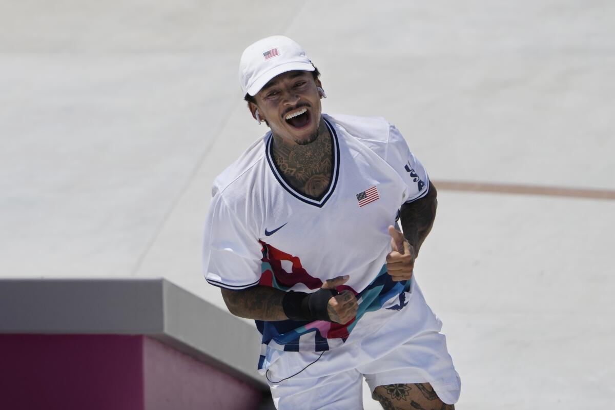 Nyjah Huston smiles and gives thumbs up during a run at the men's street skateboarding final.