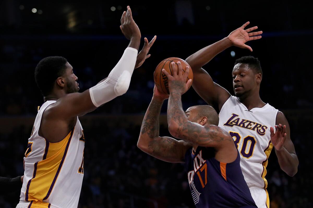 Lakers frontcourt players Roy Hibbert and Julius Randle try to block the shot of Suns forward P.J. Tucker.
