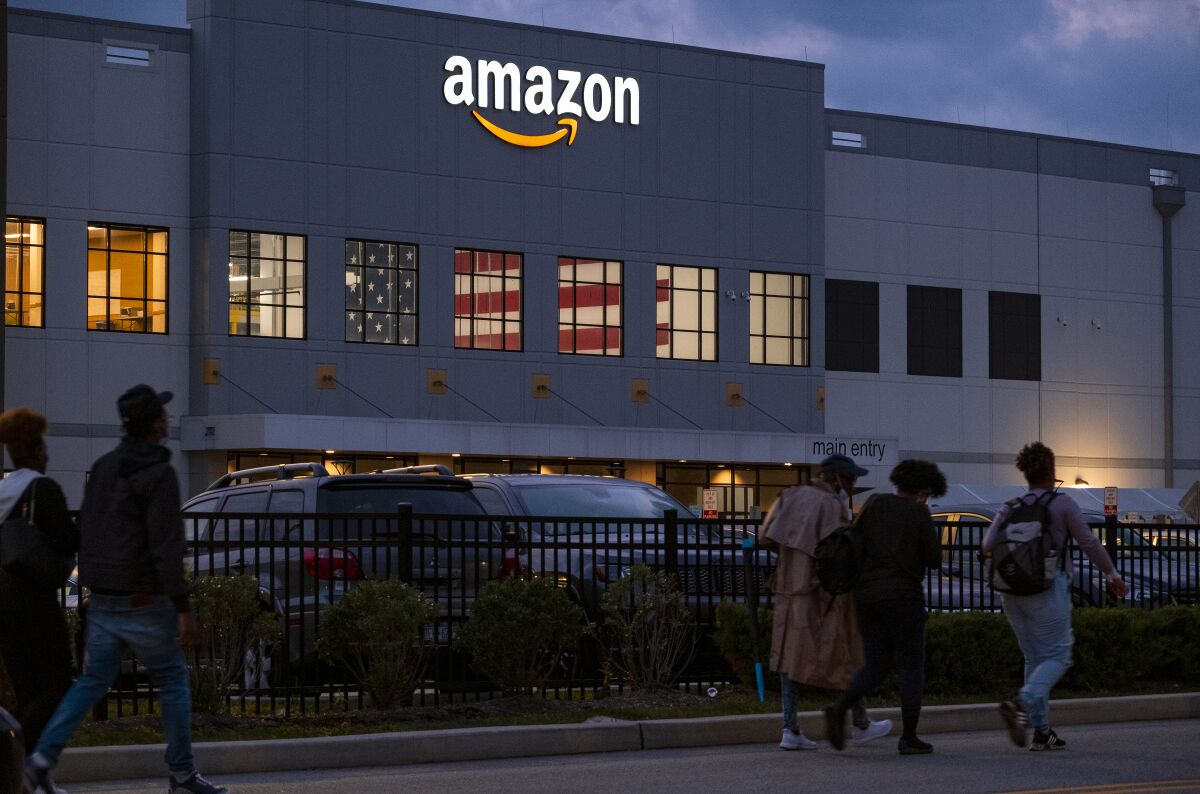 FILE - People arrive for work at the Amazon distribution center in the Staten Island borough of New York, on Oct. 25, 2021. A federal labor board has denied Amazon's request to bar the public from a hearing on the company's bid to overturn a historic union win at one of its Staten Island, New York, warehouses. (AP Photo/Craig Ruttle, File)