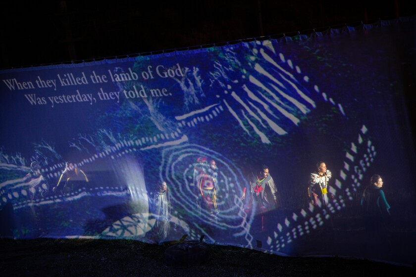 An early sequence from “Sweet Land” features Tongva patterns projected on a scrim.