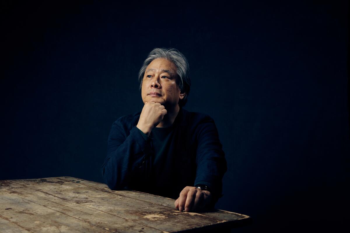 Director Park Chan-wook sits at a rustic table for a portrait
