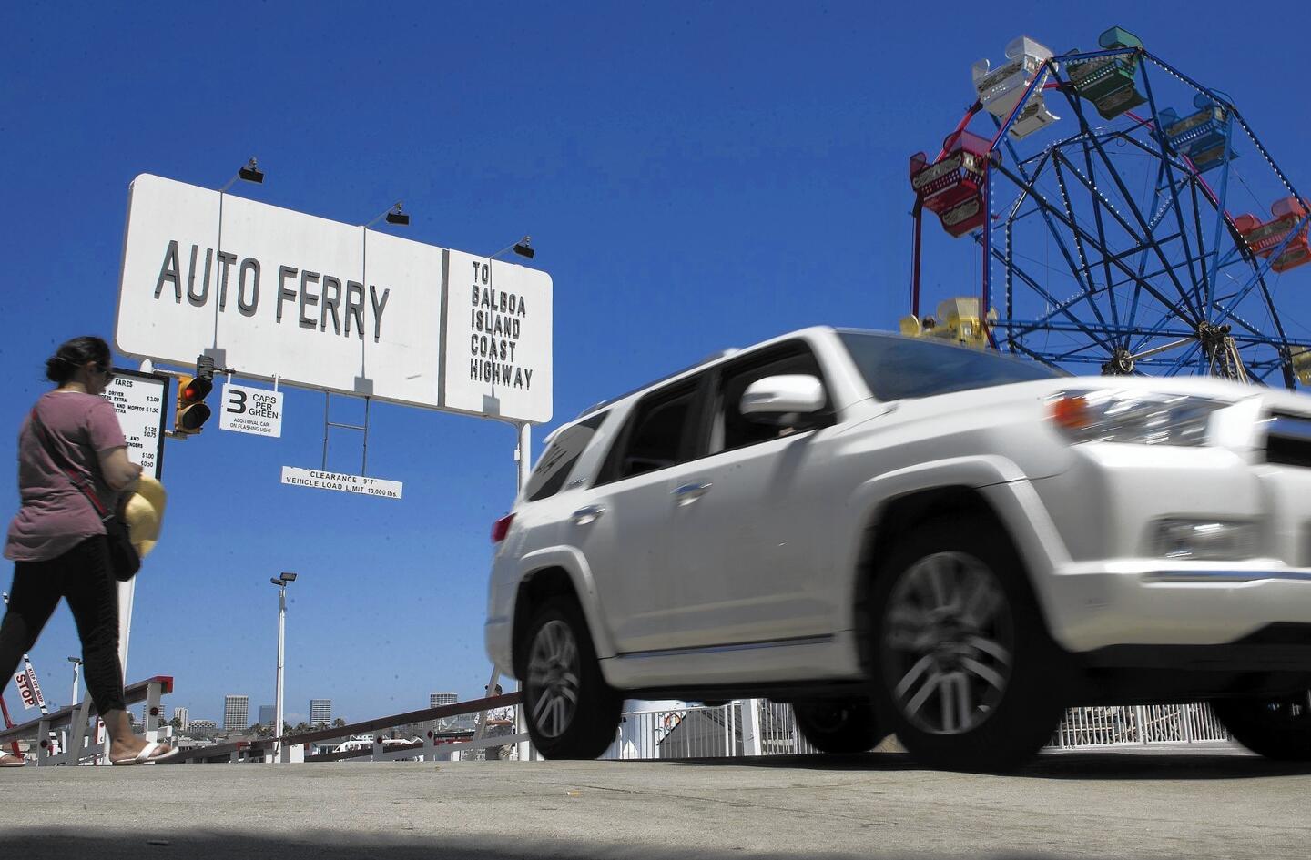 A motorist exits the Auto Ferry at Palm Street near the Balboa Fun Zone in Newport Beach on Friday.