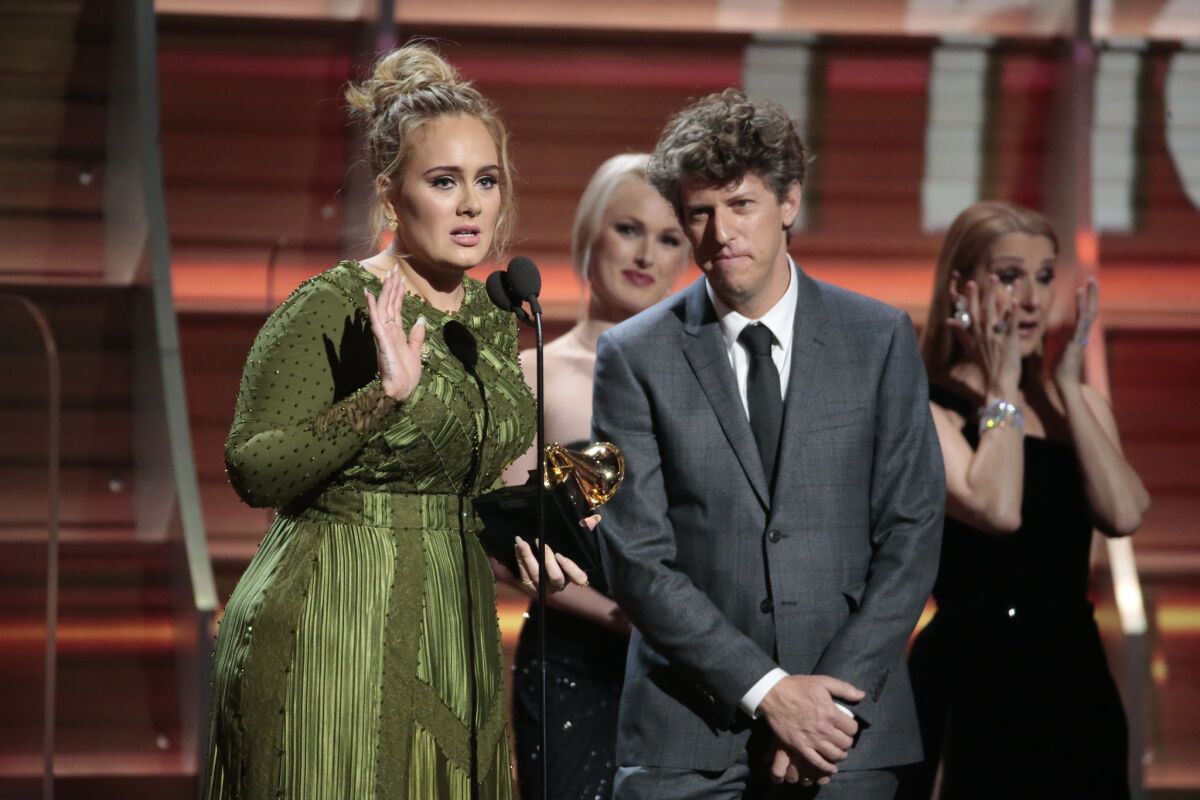 Adele receives the Grammy for song of the year as her producer Greg Kurstin looks on during the 59th Grammy music Awards.
