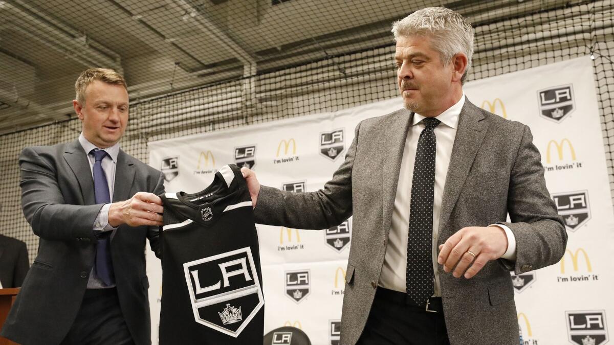 Kings general manager Rob Blake, left, presents a personalized team jersey to Todd McLellan.