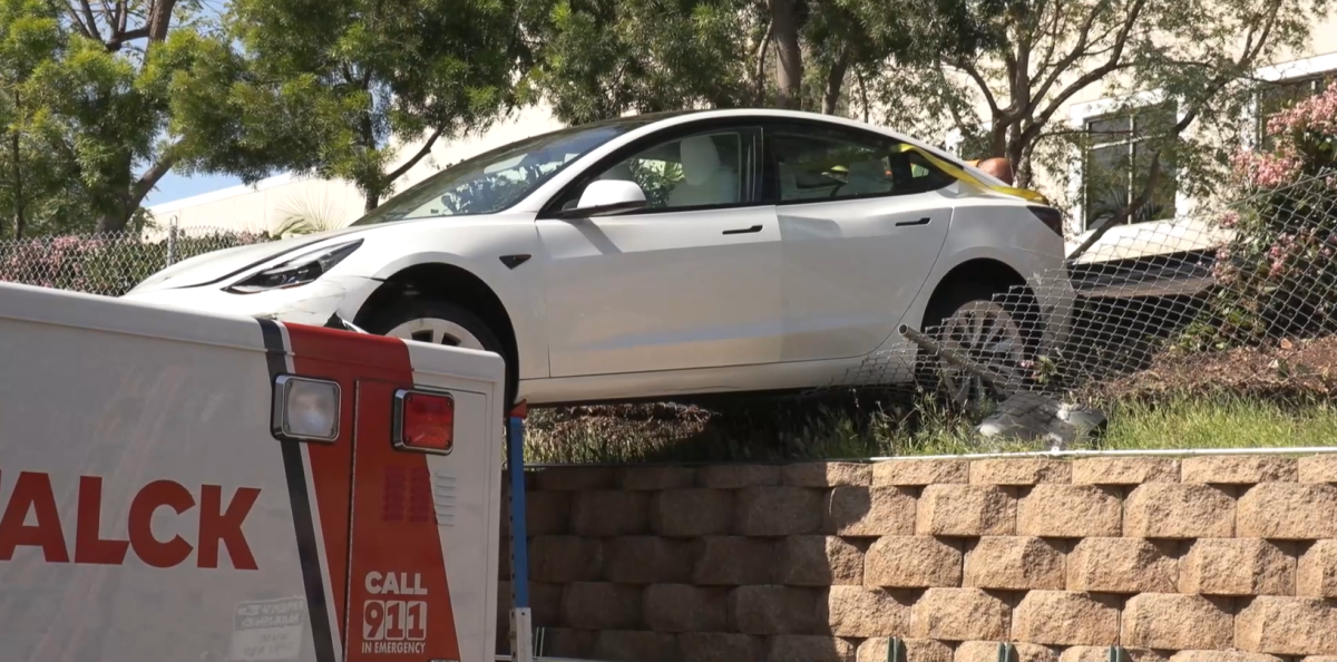 A Tesla's front end rests on top of an ambulance