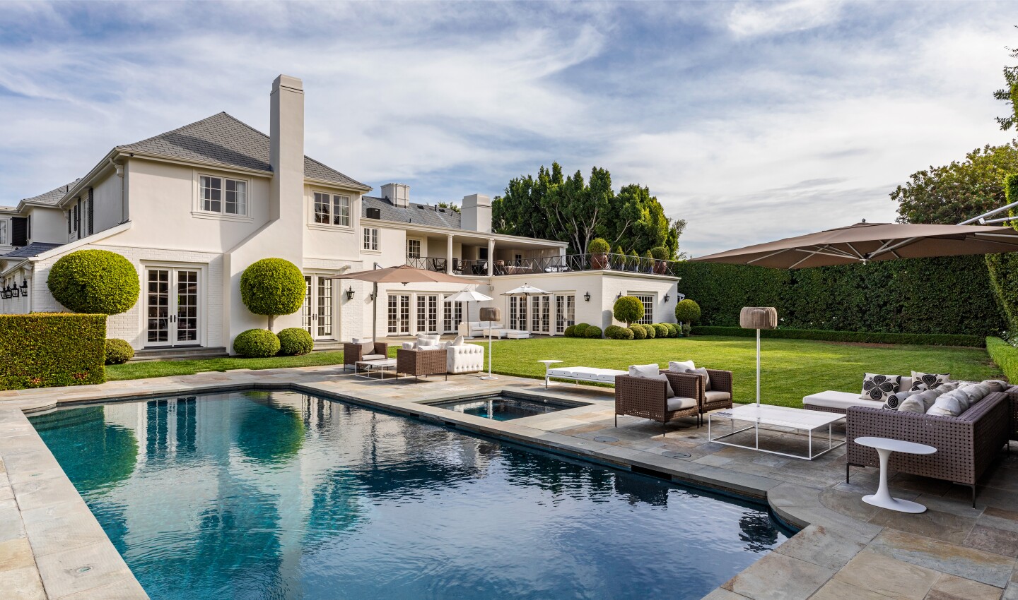 Secluded behind mature hedges and a 12-foot gate, the traditional-style home includes two guesthouses and a cabana.