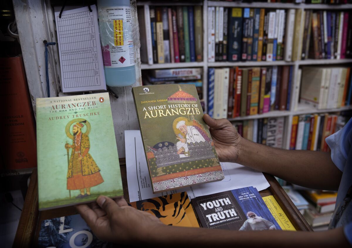 A book seller shows books on Aurangzeb in New Delhi, Thursday, June 2, 2022. For more than three centuries, Mughal emperor Aurangzeb remained relegated to India's history books. Until recently, when Prime Minister Narendra Modi and others from his Hindu nationalist party brought him back to life as a brutal oppressor of their faith and culture. (AP Photo/Manish Swarup)