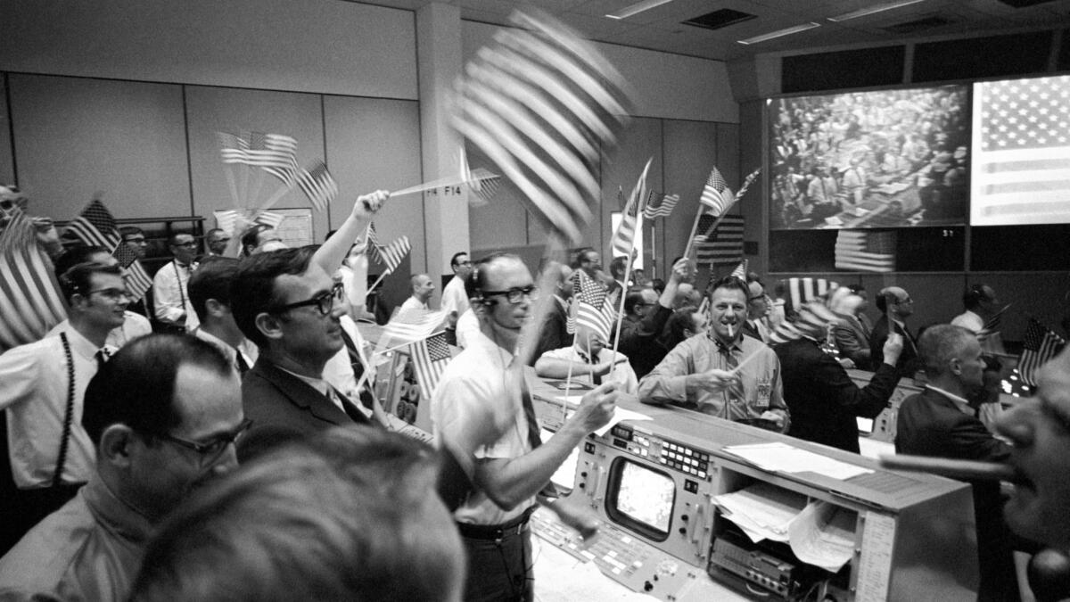 Flight controllers at the Mission Operations Control Room at the Manned Spacecraft Center in Houston celebrate the successful conclusion of the Apollo 11 lunar landing mission on July 24, 1969.