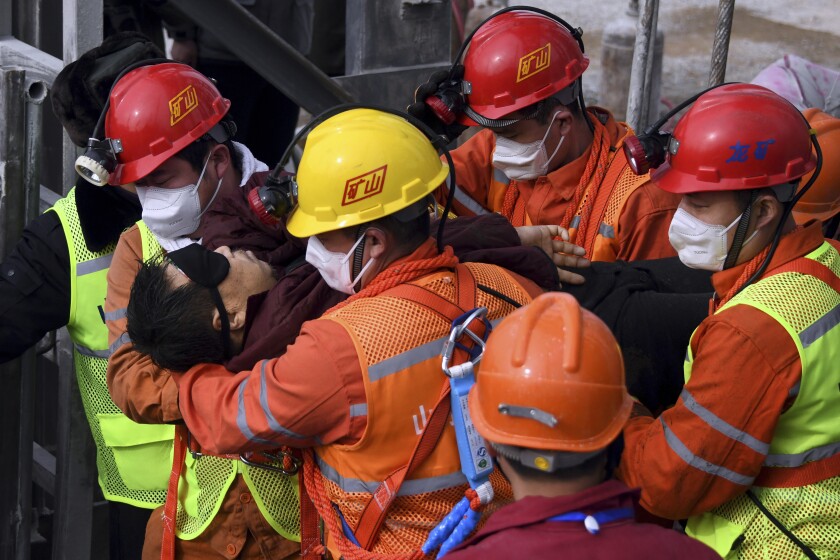 Rescuers in eastern China carry a miner who was trapped underground for two weeks to an ambulance.