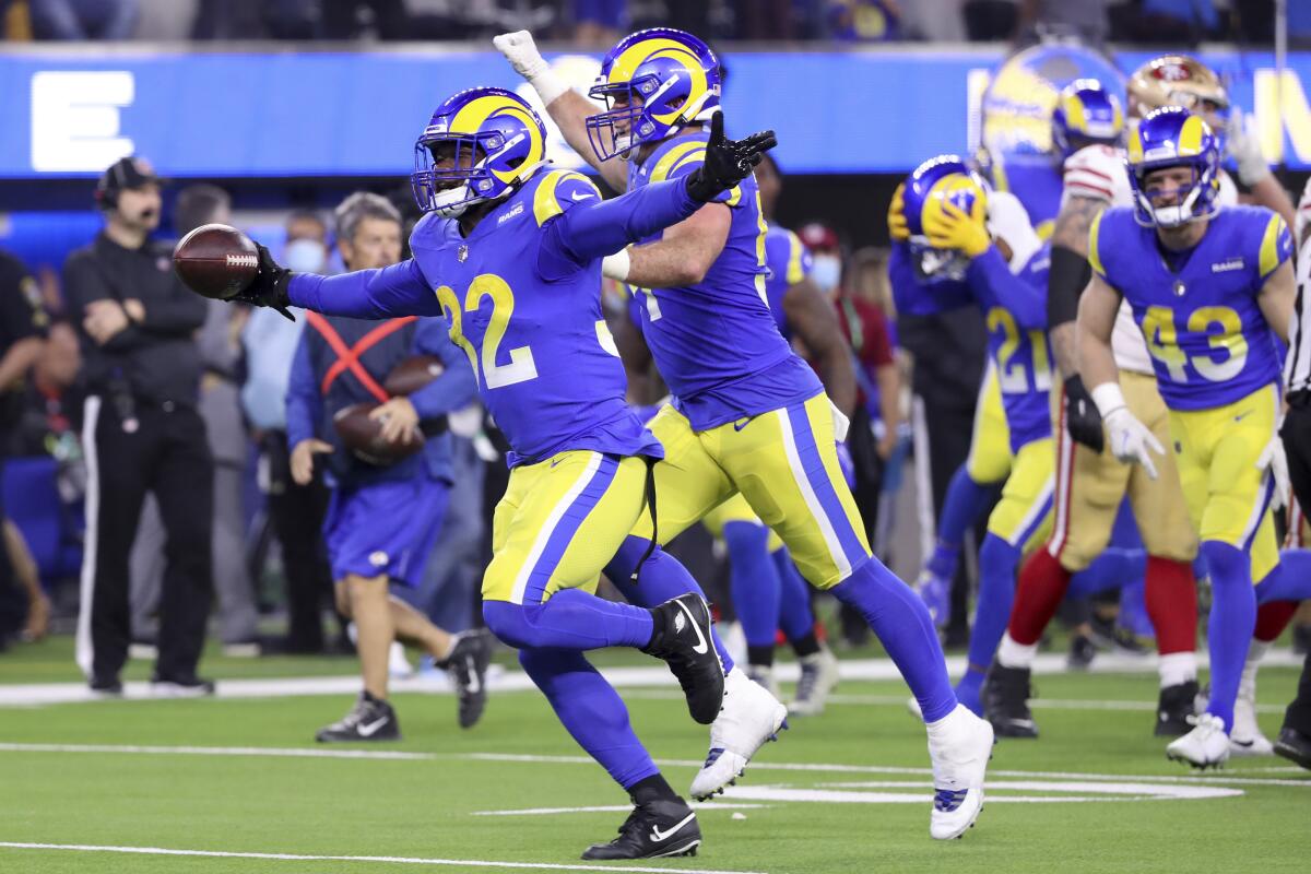 Rams linebacker Travin Howard, left, celebrates with teammates after intercepting a pass.