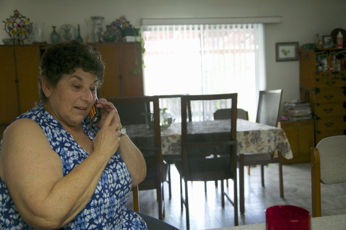 Jeri Vargas takes a phone call at her mother's home in Sherman Oaks in April. Vargas' mother gets several recorded phone calls a day.